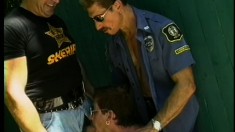 These two gay cops bring a perp to his knees and cum all over him